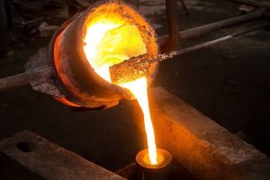 Molten metal being poured as part of an investment casting process.