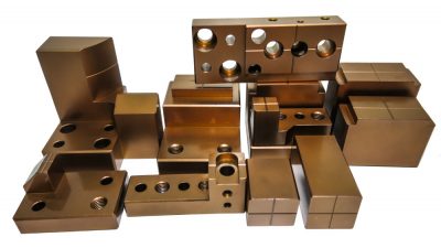 Examples of metal parts with holes created using various types of hole machining processes.