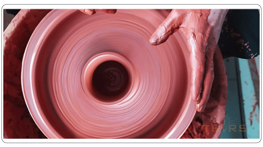 Hands shaping clay on a wheel in traditional method.