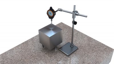 GD&T measurement of a manufactured part on a surface plate using a dial gauge.