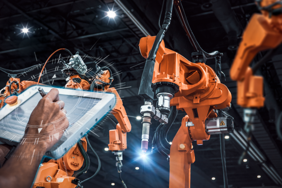 Combining automation with human expertise is shown here as a tech operates a robotic arm.