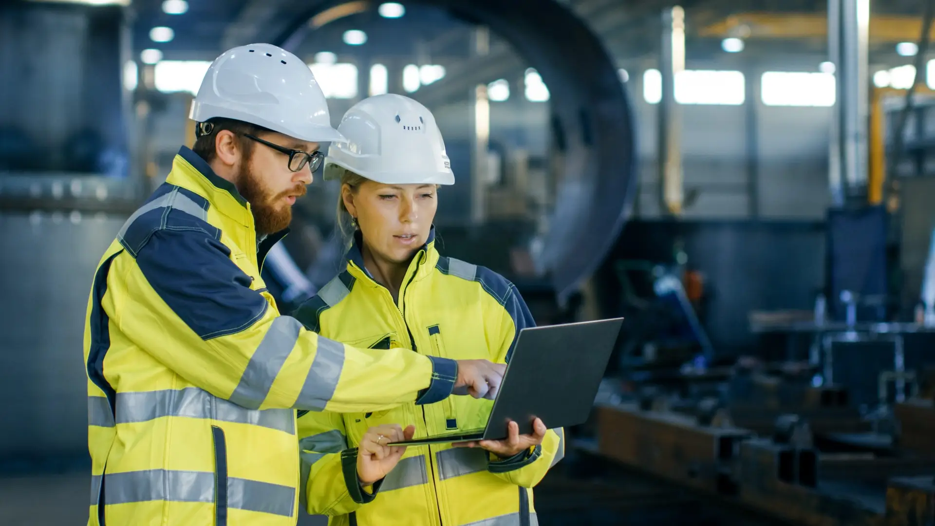 After implementing a digital checklist tool, factory workers are viewing data on a computer.