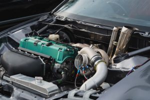 An open car bonnet showing a turbocharger in a vehicle, connected to the engine.